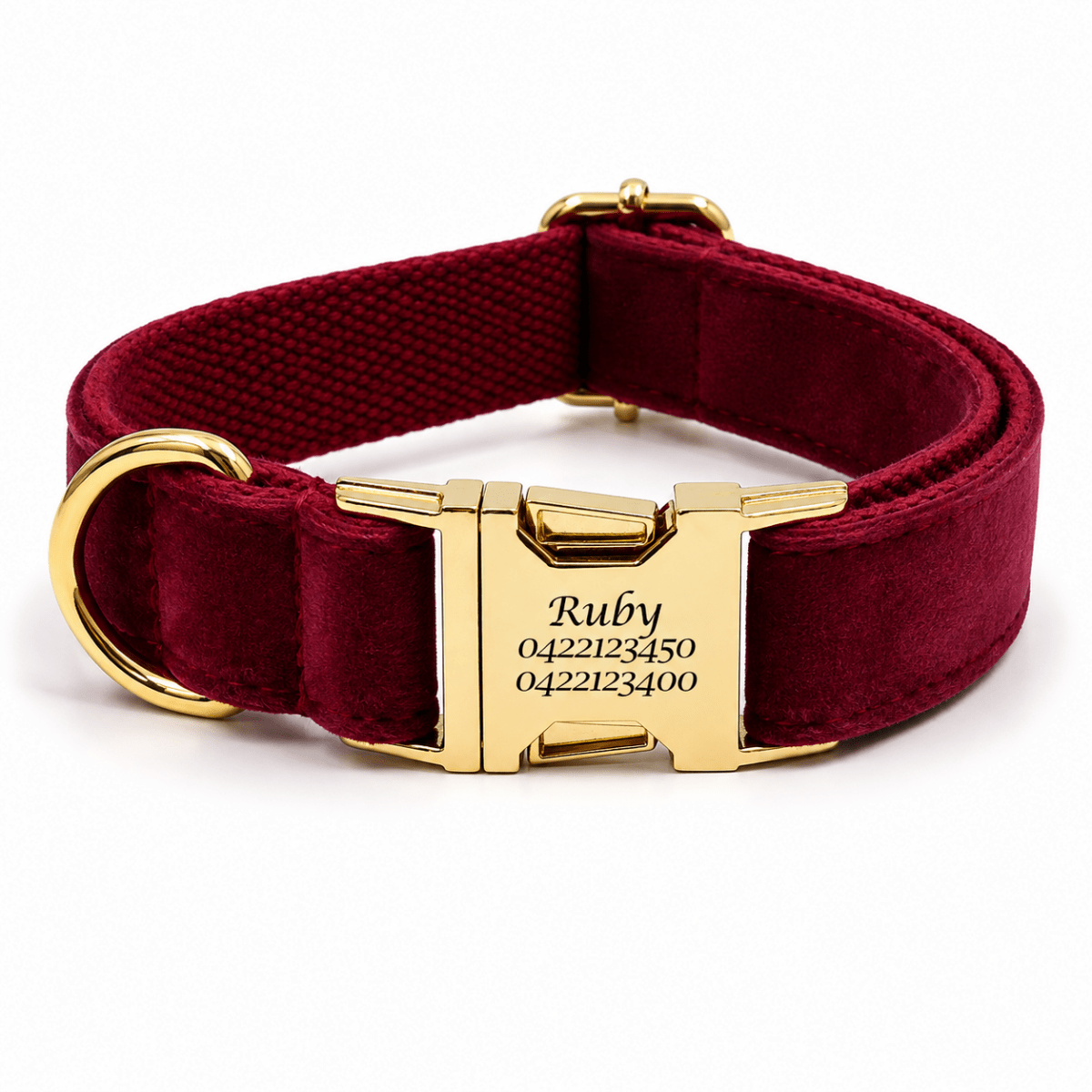 A personalized burgundy velvet dog collar with a gold-tone metal buckle engraved with the name 'Ruby' and numbers, shown on a white background.