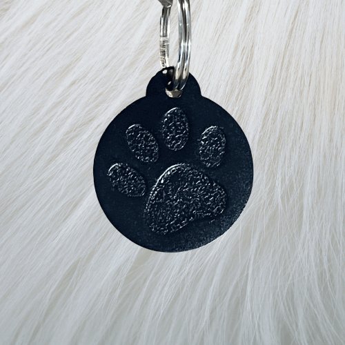 Trendy Pawzo Dog Tags for Pets featuring a stylish black paw design, perfect for keeping your pet safe and stylish.